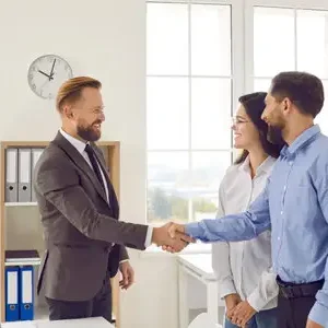 208208856-el-empleado-del-banco-le-da-la-mano-a-una-pareja-casada-después-de-firmar-con-éxito-el-contrato-y